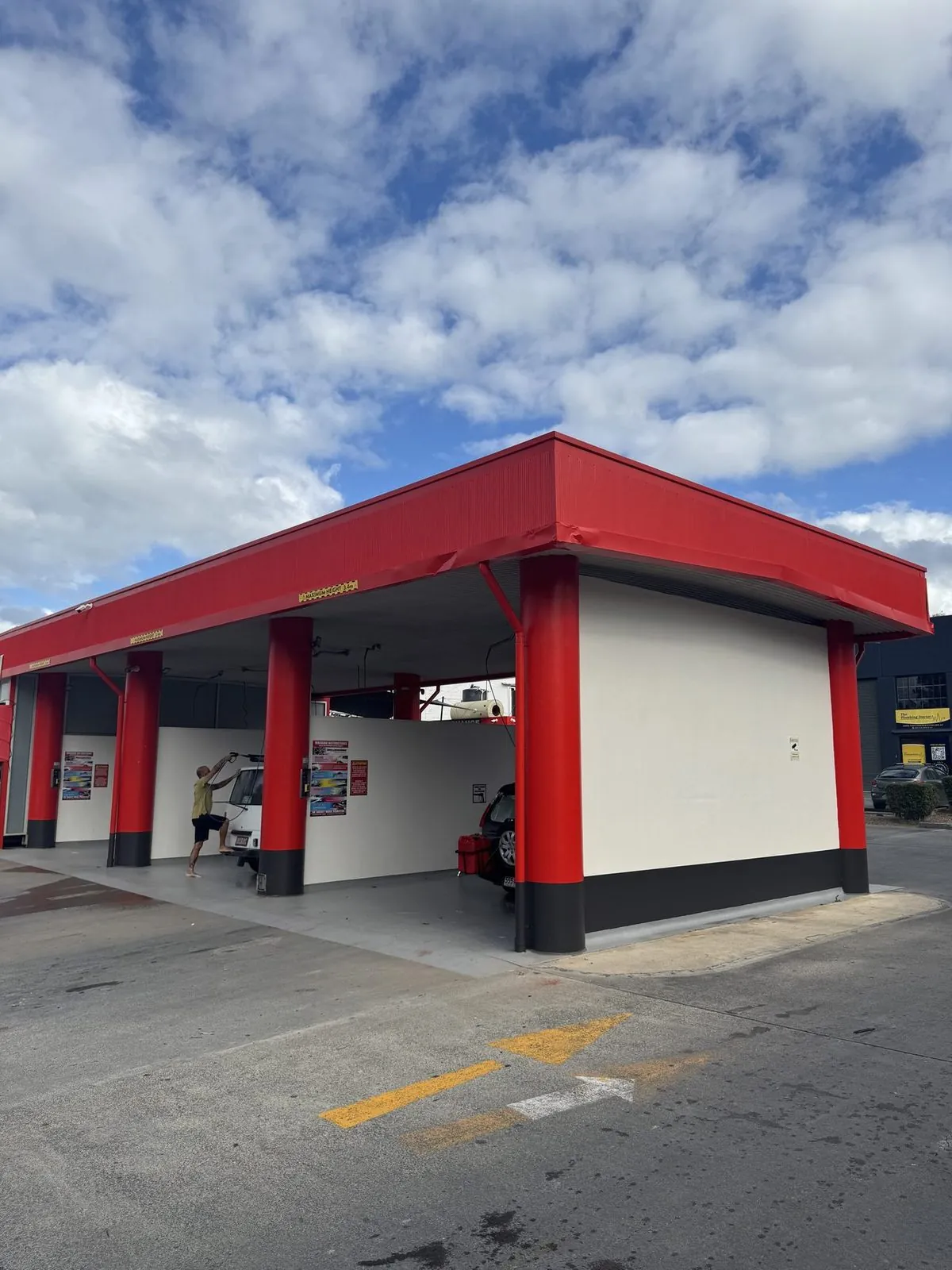 Freshly repainted car wash forecourt and wash bays with a red canopy on the Gold Coast