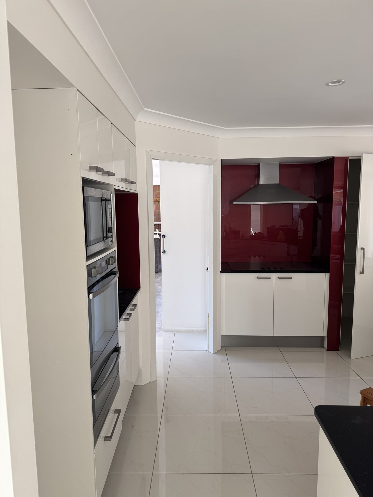 Hallway and kitchen with a dark feature wall at Terranora