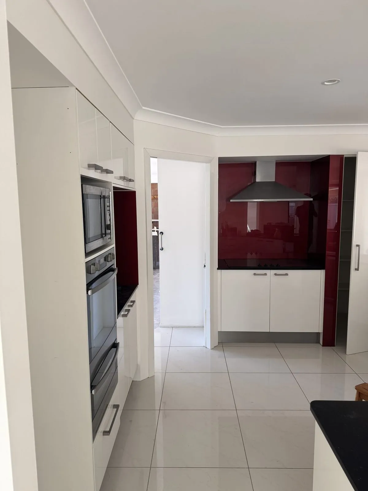 Hallway and kitchen with a dark feature wall at Terranora